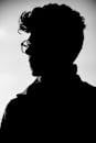 Artistic black and white profile silhouette of a man wearing eyeglasses.